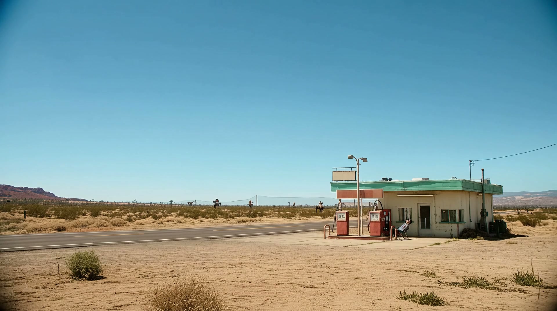 A wide view of a Western desert road and vintage gas station establishing the story setting.